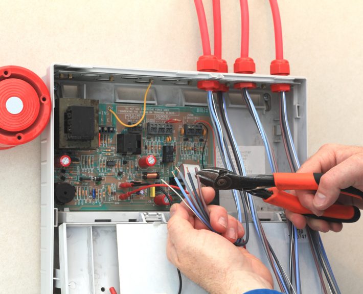 Electrician working at a Fire Alarm control box.